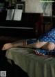 A woman laying on top of a table next to a piano.