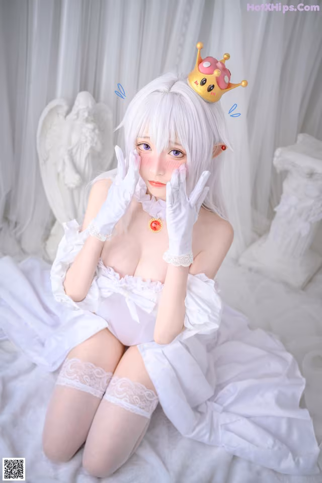 A woman in a white dress with a crown on her head.