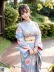 A woman in a blue kimono posing for a picture.