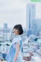 A woman standing on top of a building next to a city.