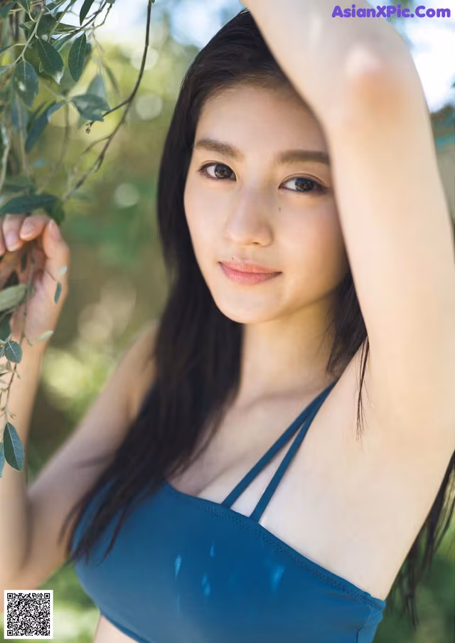 A woman in a blue bikini posing for a picture.
