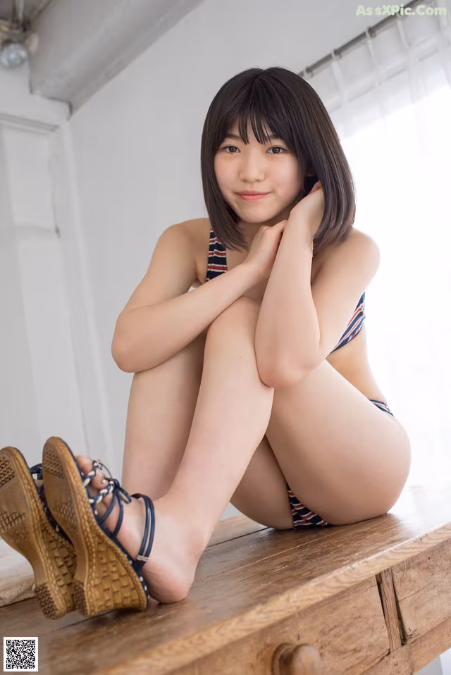A woman sitting on top of a wooden table.