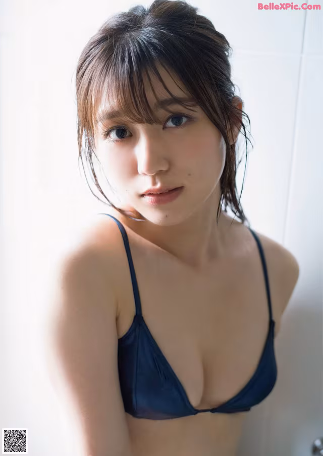 A woman in a blue bikini posing for a picture.
