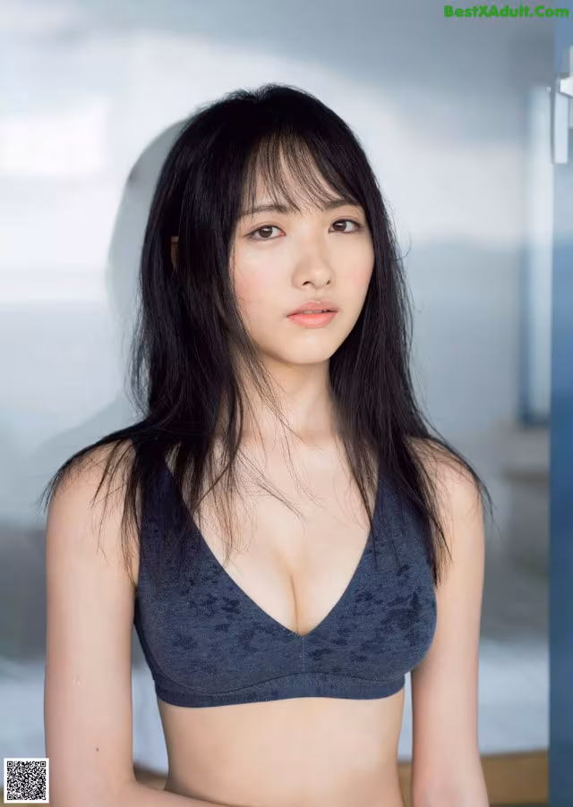 A woman in a gray bra top posing for a picture.