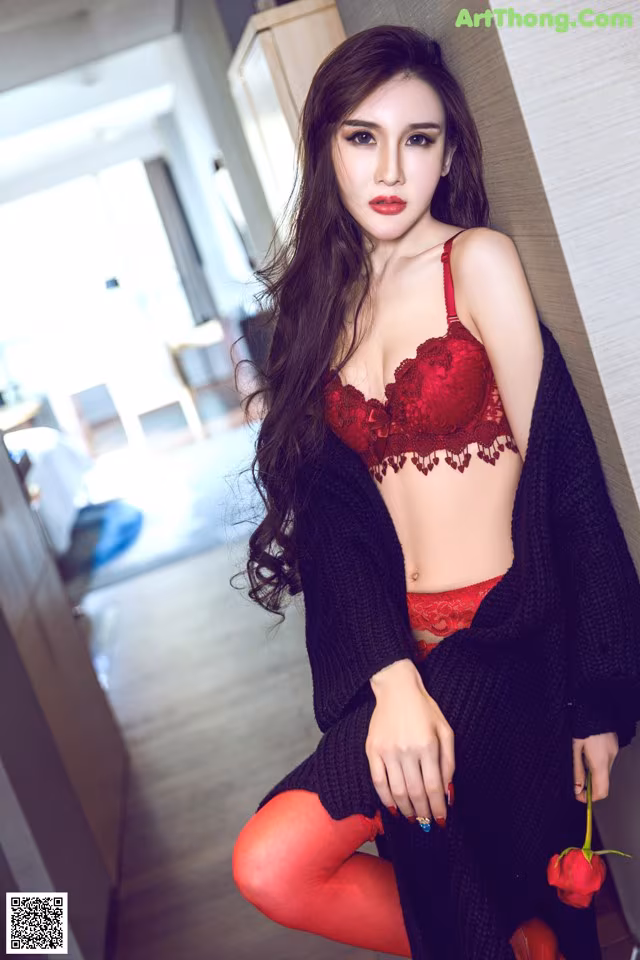 A woman in a red lingerie posing for a picture.