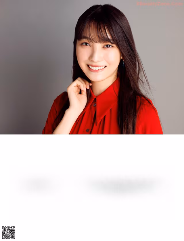 A woman in a red shirt is posing for a magazine.