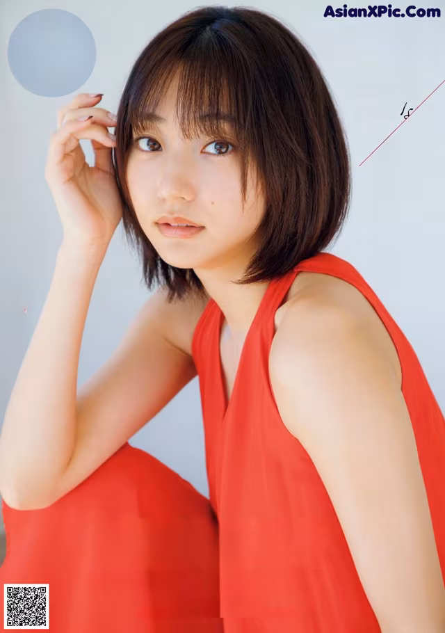 A woman in a red dress posing for a magazine cover.