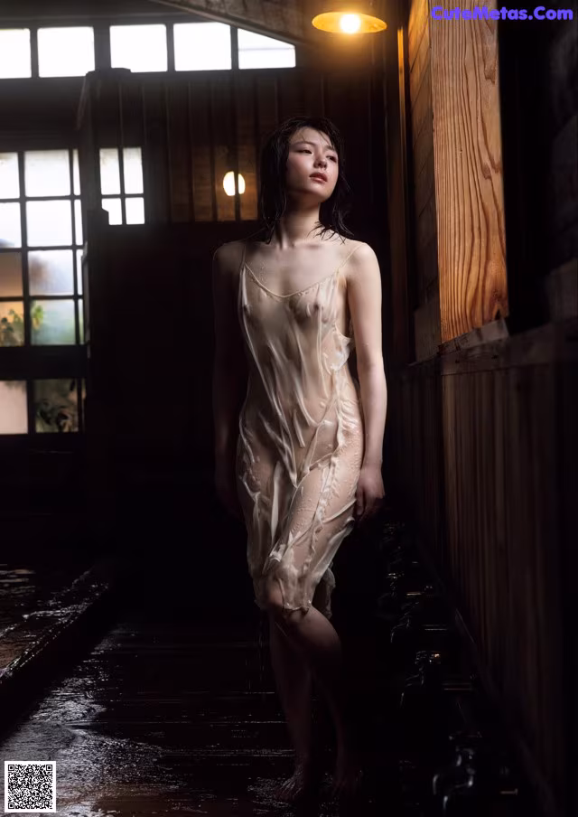 A woman in a white dress standing in a room.