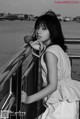 A woman leaning on a railing by the water.