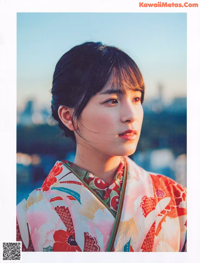A woman in a kimono poses for a picture.
