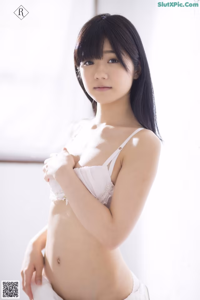 A woman in a white bra and panties posing for a picture.