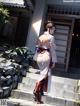 A woman in a white kimono and red boots standing on some steps.